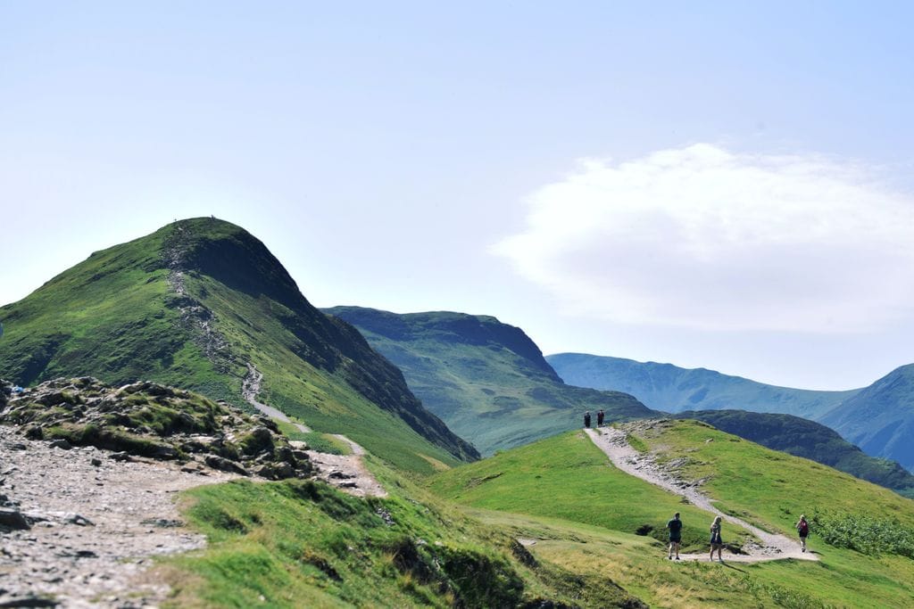Walkers on a walking trail winding up the side of a montain