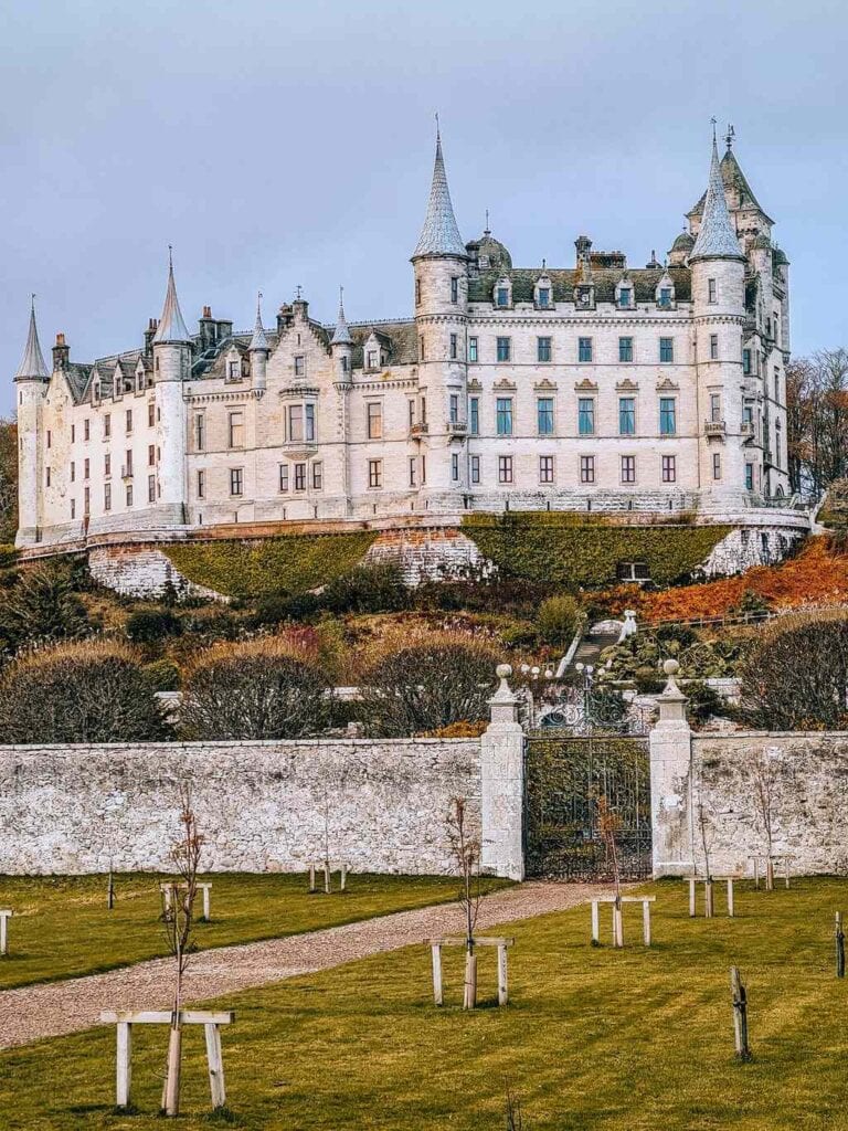 Dunrobin Castle on a hill with turrets and a walled garden in front near Inverness for Scotland staycation
