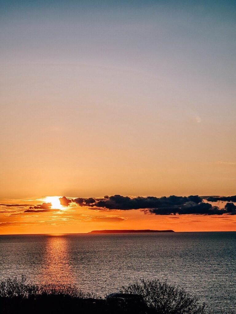Lundy Island can be seen in the distance on the horizon at sunset in North Devon
