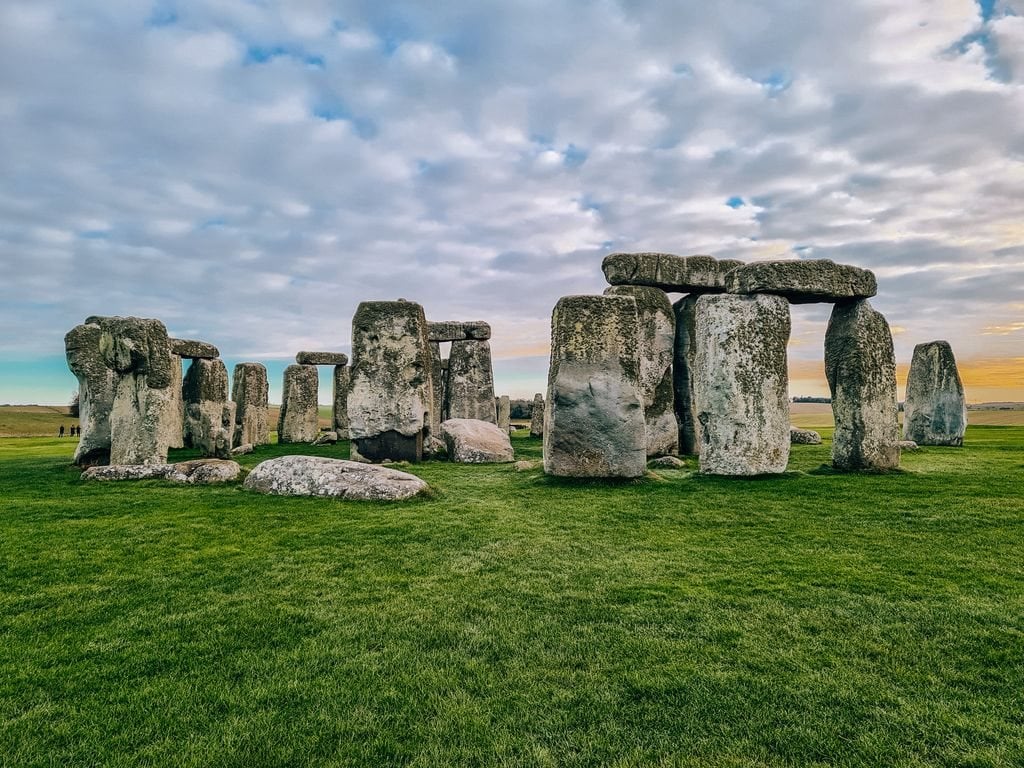Green grass with the big stone structure of Stonehenge in the background.